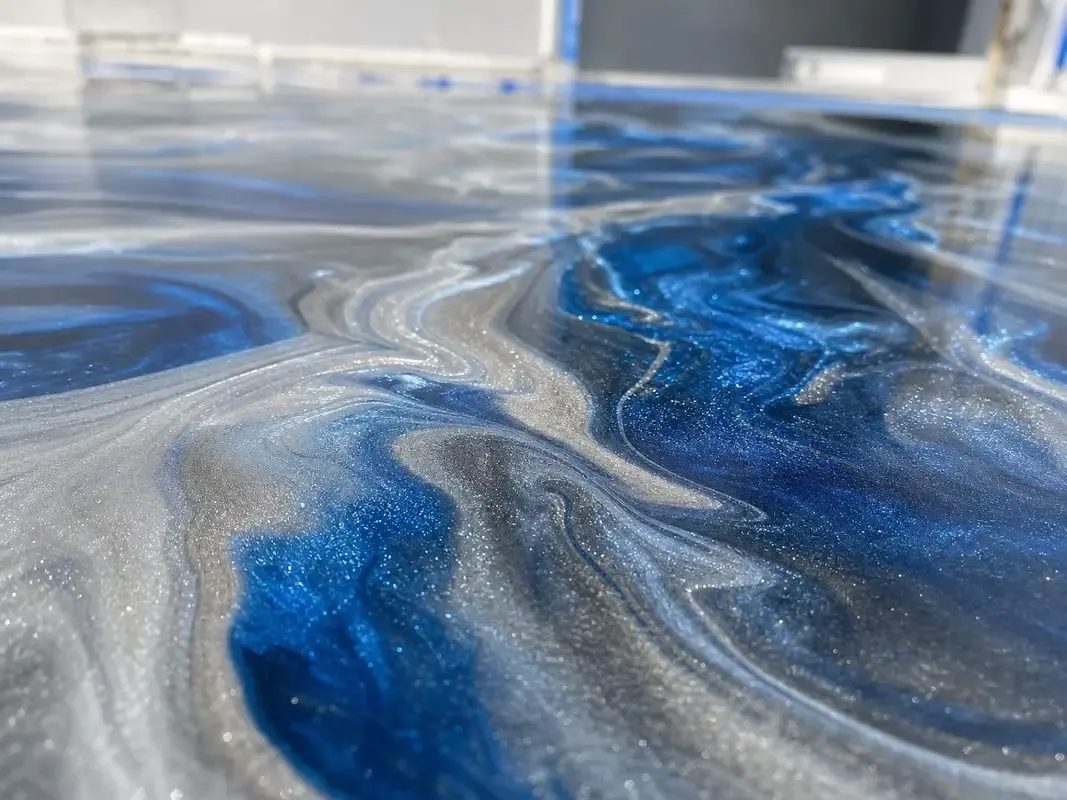 Metallic epoxy installation process showing blue and silver pigment movement